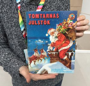 Daniel Björklund håller i julboken Tomtarnas julstök av Maryjane H Tonn med illustrationer av George Hinke 